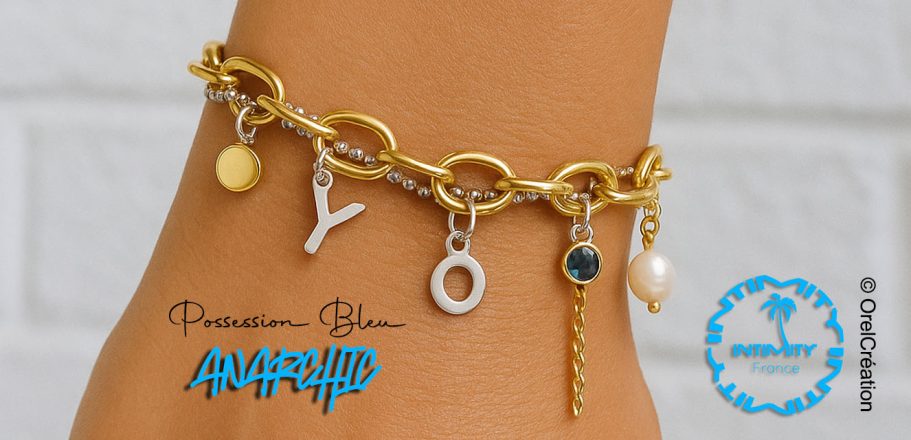 collection Anarchic pièce unique Bracelet en chaîne dorée avec des pendentifs variés, dont une perle et des lettres.
