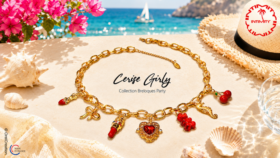 Cerise Girly Bracelet en or avec breloques rouges sur une plage ensoleillée.